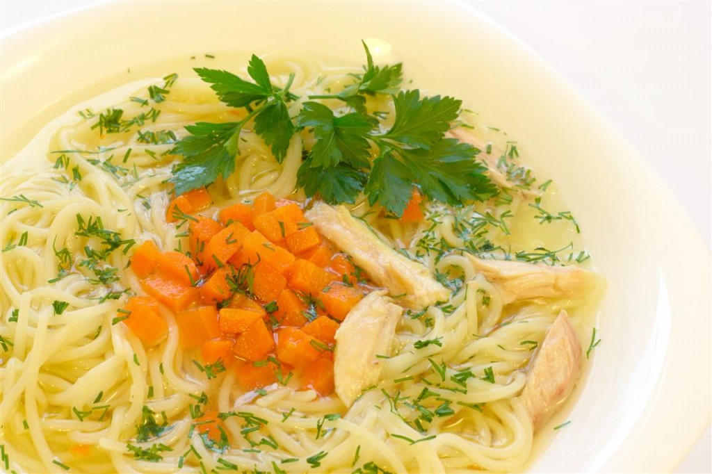 Portion of a chicken soup with spaghetti and single parsley twig