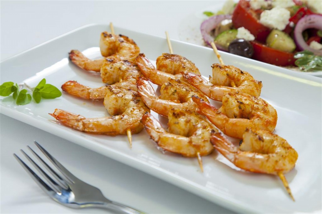 Spicy chili shrimp skewers with a traditional Greek salad